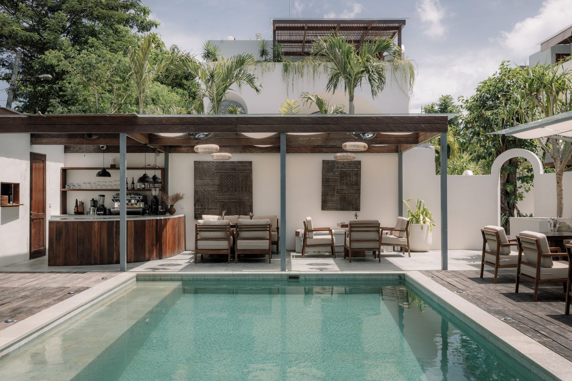 The pool in the morning, loungers along the deck and Bonnie’s bar under the canvas at the far end.